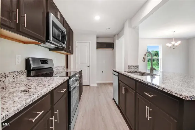 a kitchen with stainless steel appliances granite countertop a sink stove and refrigerator