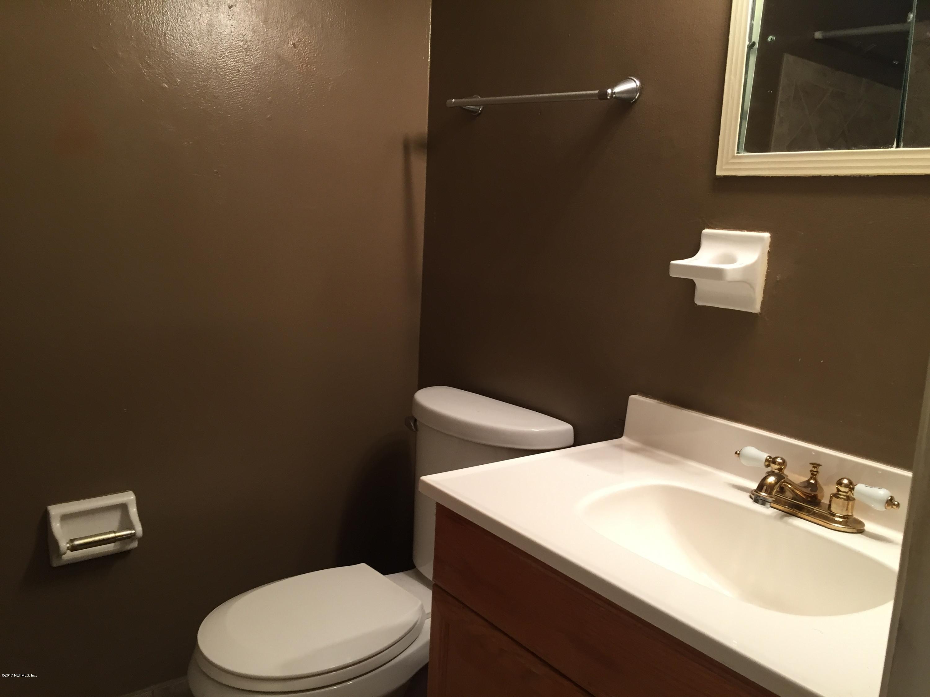 5838 Ensenada Road Jacksonville, FL 32244 - Photo 13 of 23 a bathroom with a sink a toilet and mirror