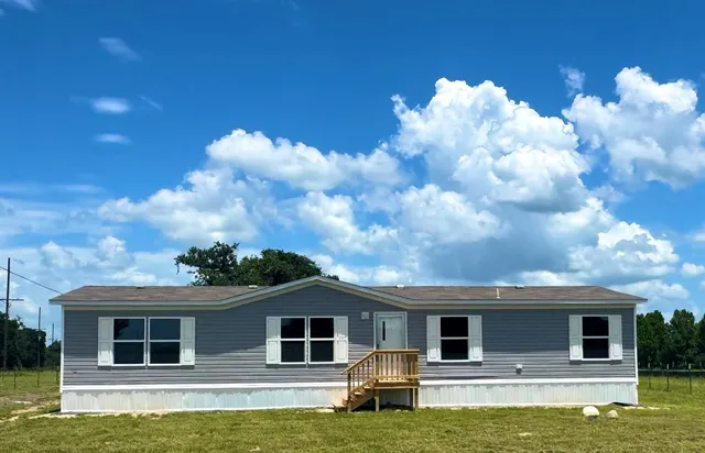 a front view of house with yard garden and barbeque oven