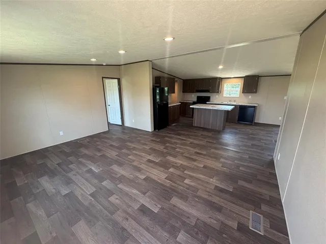 a view of a hallway with wooden floor and furniture