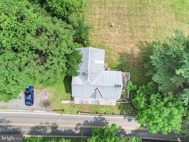 an aerial view of a house with a yard and large tree