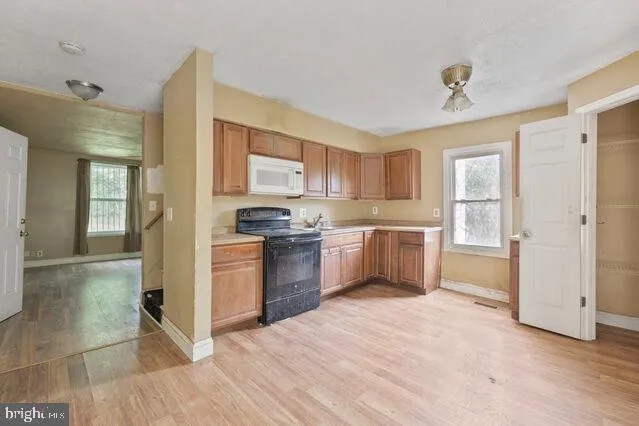 a kitchen with granite countertop a refrigerator and a stove top oven