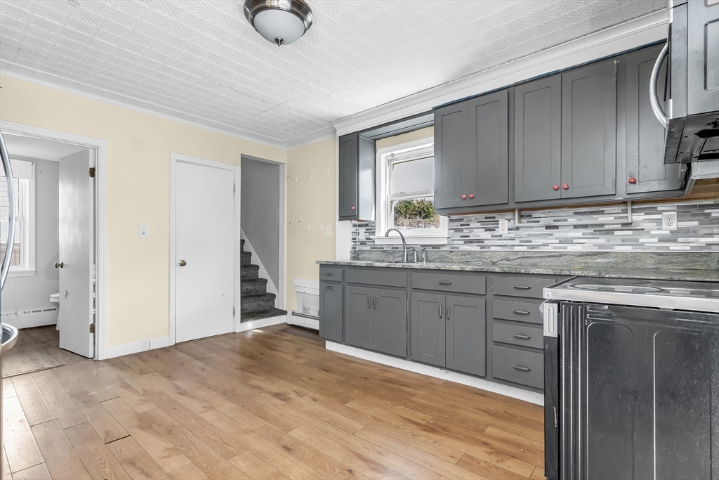 157 Cilley Road Manchester, NH 03103 - Photo 5 of 34 a kitchen with stainless steel appliances granite countertop a sink cabinets and wooden floor