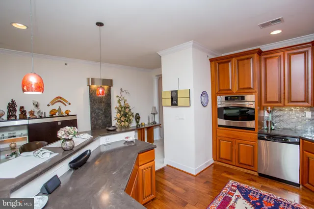 a kitchen with stainless steel appliances granite countertop a refrigerator and wooden cabinets