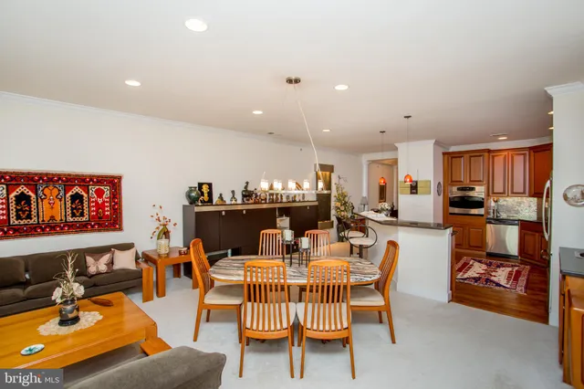 a living room with furniture kitchen view and a flat screen tv