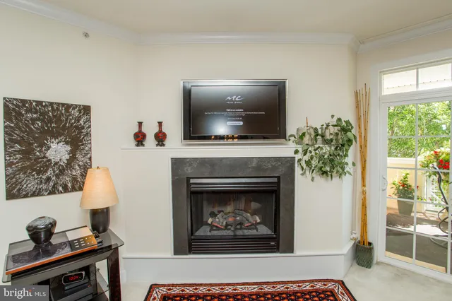 a balcony with table and chairs potted plants and floor to ceiling window