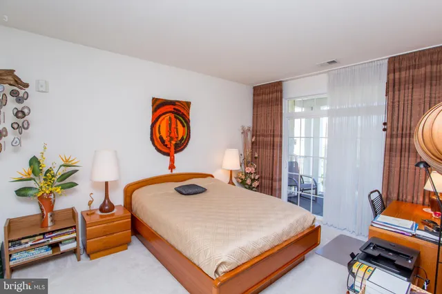 a bedroom with a bed and a lamp on dresser