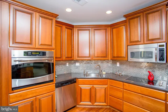 a kitchen with stainless steel appliances granite countertop a refrigerator and a stove top oven