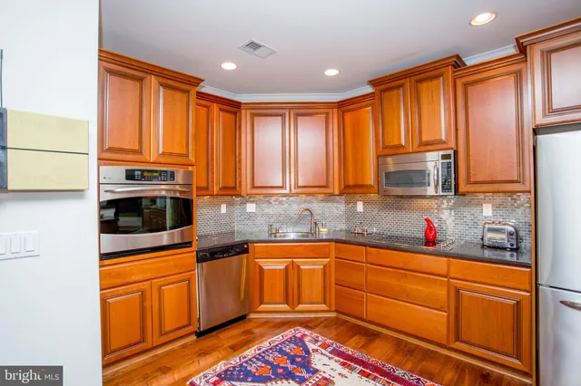 a kitchen with stainless steel appliances granite countertop a stove and a dining table