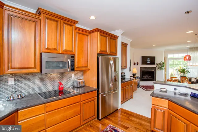 a kitchen with stainless steel appliances granite countertop a refrigerator and a stove top oven