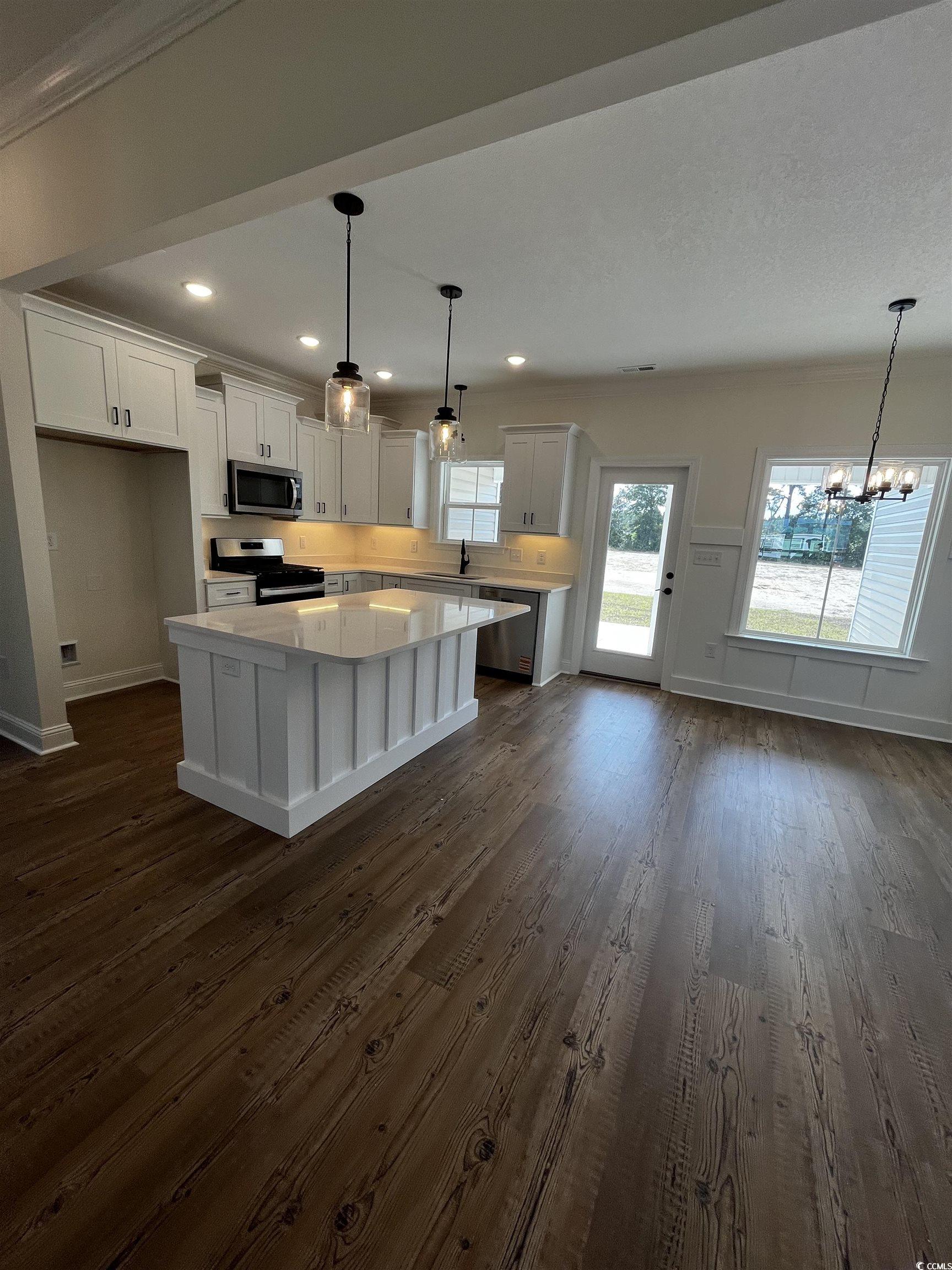 3420 Asbury Road Aynor, SC 29511 - Photo 3 of 8 Kitchen featuring a kitchen island, a chandelier, white cabinetry, stainless steel appliances, and decorative light fixtures