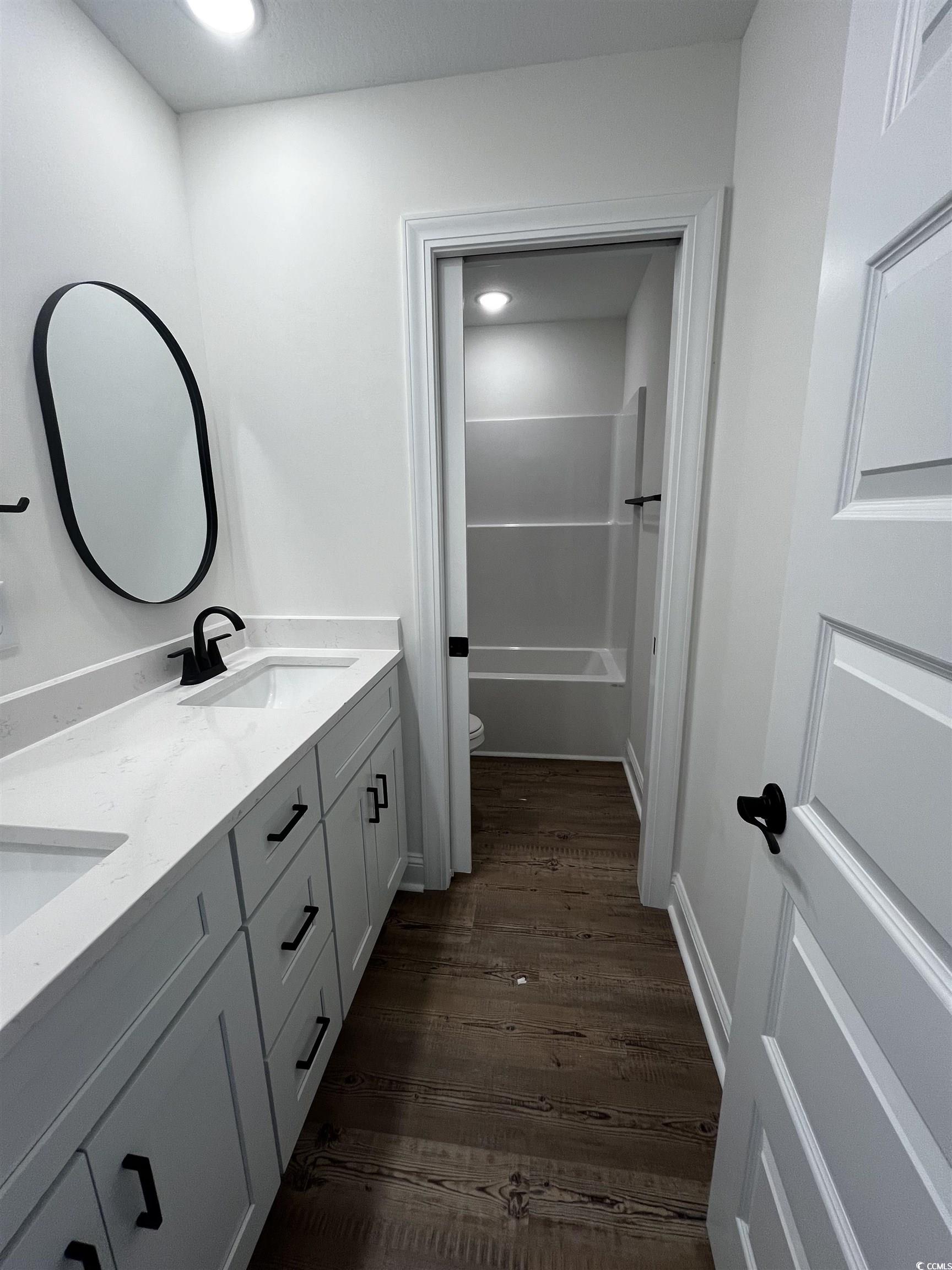 3420 Asbury Road Aynor, SC 29511 - Photo 6 of 8 Full bath with double vanity, dark wood finished floors, and shower / washtub combination