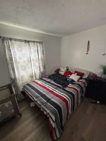 a bed sitting in a bedroom next to a window