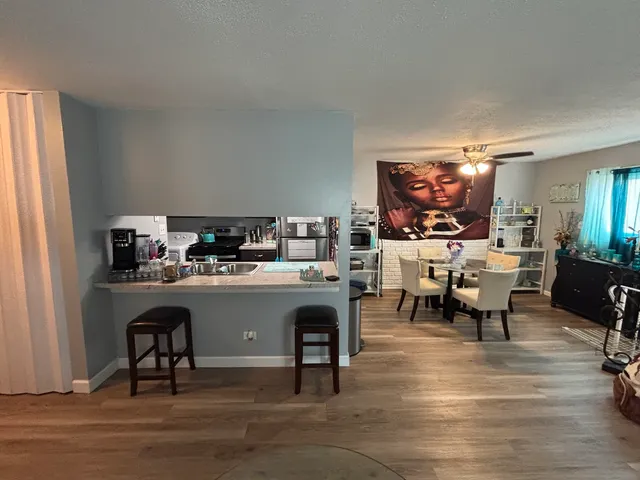 a living room with stainless steel appliances kitchen island granite countertop furniture and a fireplace