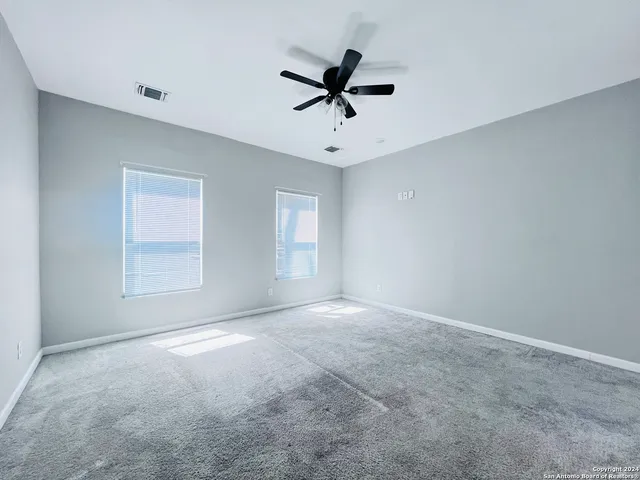 a view of room with a ceiling fan and window