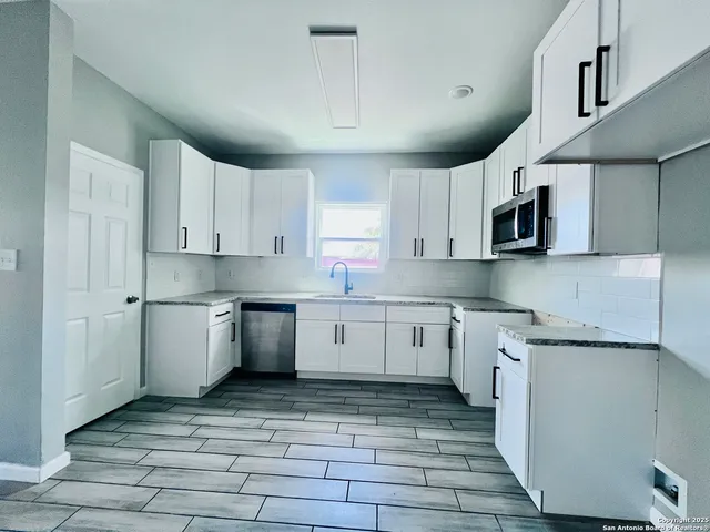 a kitchen with a sink window and cabinets