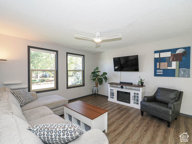 3308 Willow Ridge Road Salt Lake City, UT 84121 - Photo 28 of 59 Wood-finish flooring, two large windows, ceiling fan, and built-in media console with integrated electric fireplace