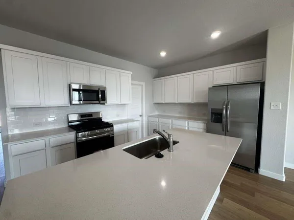 a kitchen with kitchen island white cabinets appliances and sink