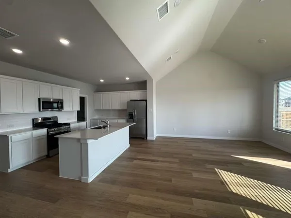 a large kitchen with a stove top oven and sink
