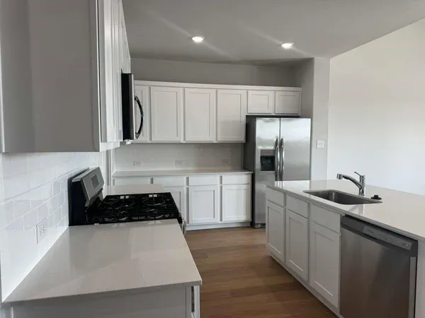 a kitchen with stainless steel appliances a sink stove and refrigerator