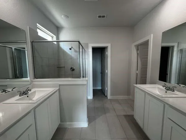 a bathroom with a double vanity sink and mirror