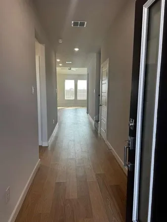 a view of a hallway with wooden floor