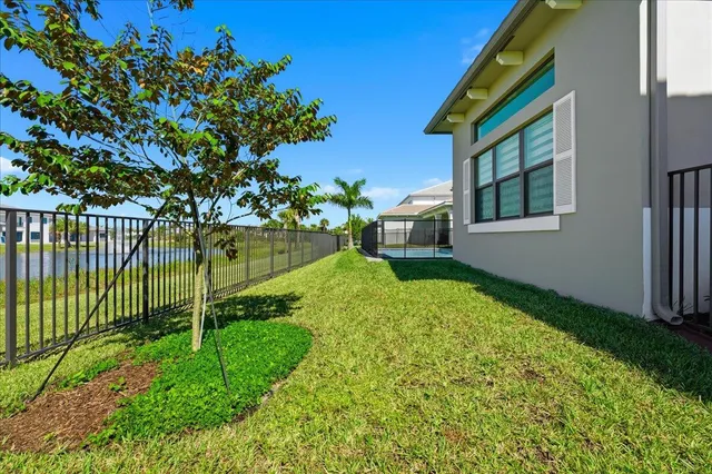 a view of a house with backyard and a tree