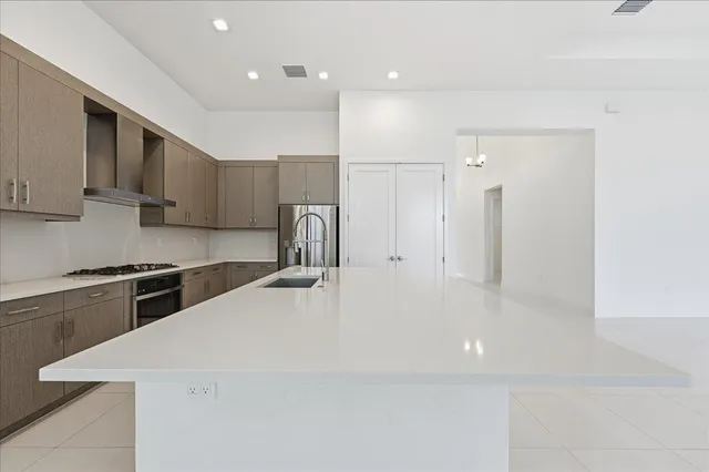 a large white kitchen with stainless steel appliances