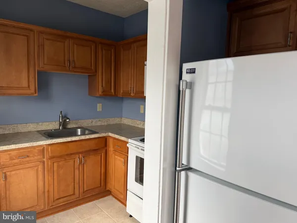 a kitchen with a sink a refrigerator and cabinets