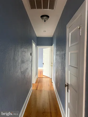 a view of a hallway with wooden floor and a chandelier