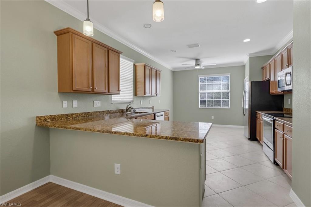 2391 Heydon Circle East Naples, FL 34120 - Photo 11 of 42 a kitchen with granite countertop a sink a counter top space appliances and cabinets