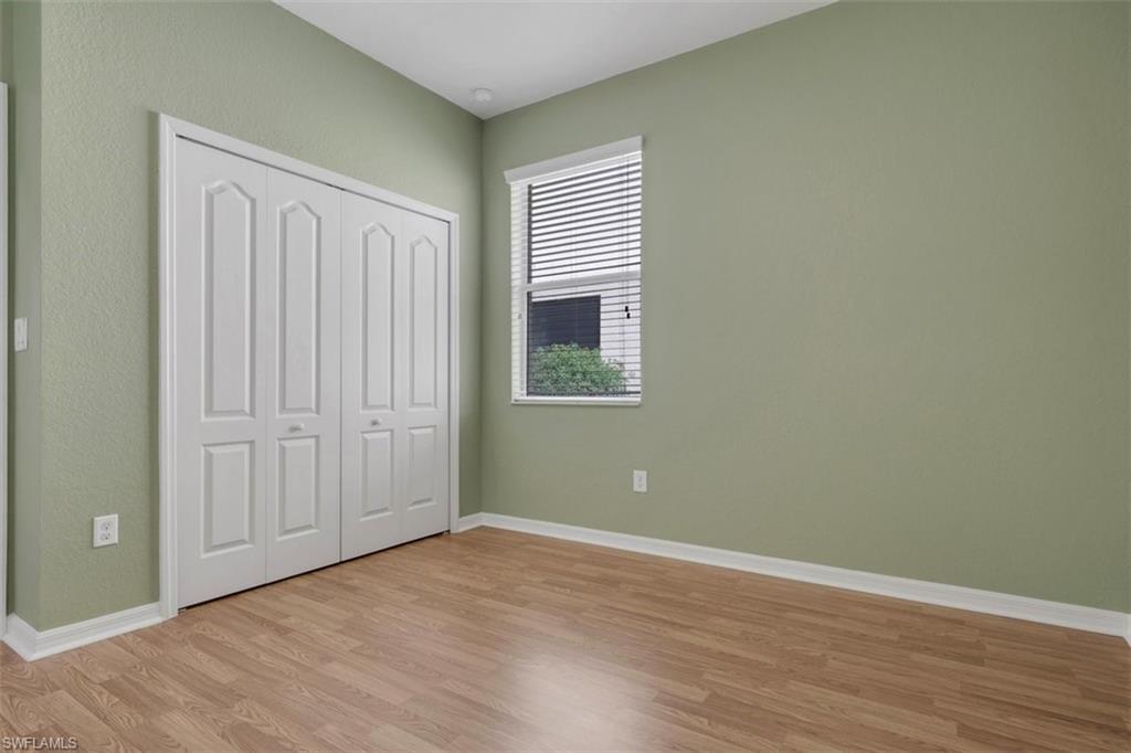 2391 Heydon Circle East Naples, FL 34120 - Photo 24 of 42 an empty room with wooden floor and windows