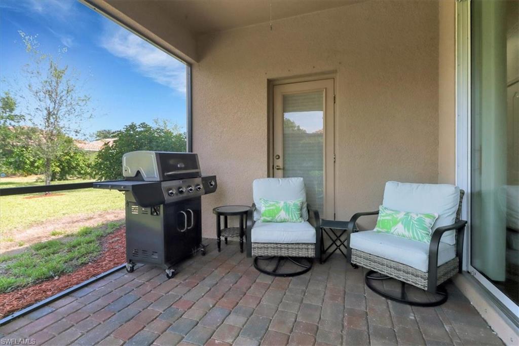 2391 Heydon Circle East Naples, FL 34120 - Photo 30 of 42 a living room with furniture and a floor to ceiling window