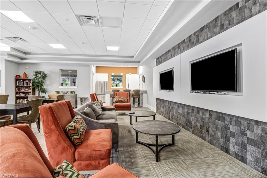 2391 Heydon Circle East Naples, FL 34120 - Photo 39 of 42 a living room with furniture a flat screen tv and a chandelier