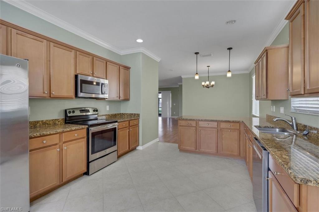 2391 Heydon Circle East Naples, FL 34120 - Photo 7 of 42 a kitchen with stainless steel appliances granite countertop a sink stove and microwave