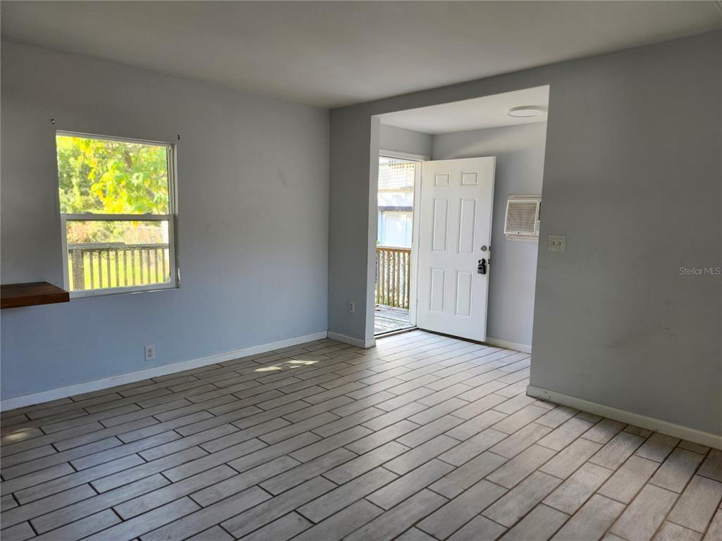 422 Northwest 9th Avenue Gainesville, FL 32601 - Photo 5 of 9 a view of an empty room with wooden floor and a window