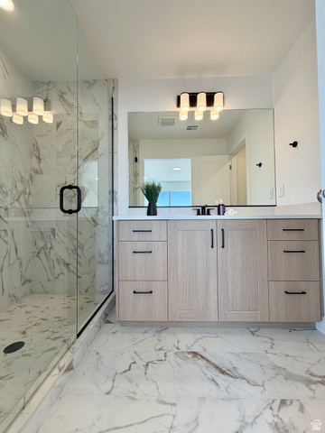 915 West Gold Ridge Ln Street St. George, UT 84790 - Photo 13 of 30 Contemporary bathroom featuring a spacious glass-enclosed shower with white marble-look tile, a light wood-finish vanity with black hardware, a rectangular vanity mirror, and a modern five-bulb light fixture
