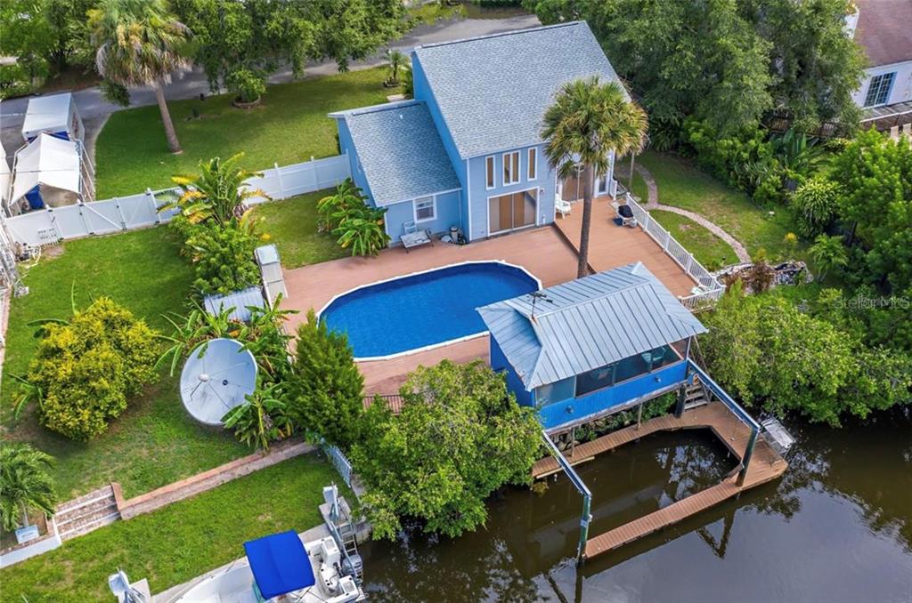 an aerial view of a house with swimming pool a patio and yard