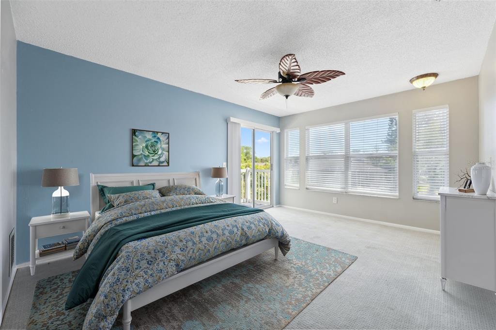 428 West Klosterman Road Palm Harbor, FL 34683 - Photo 12 of 44 a bedroom with a large bed and a chandelier