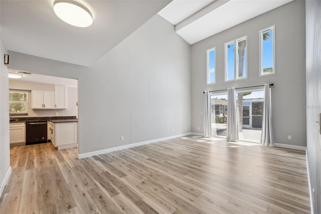428 West Klosterman Road Palm Harbor, FL 34683 - Photo 7 of 44 a view of a kitchen with an empty room and wooden floor