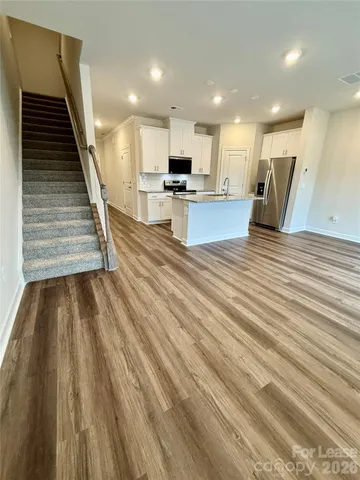 a view of kitchen with sink and refrigerator