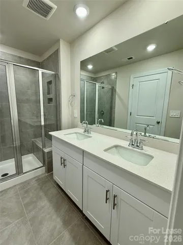 a bathroom with a double vanity sink toilet and shower