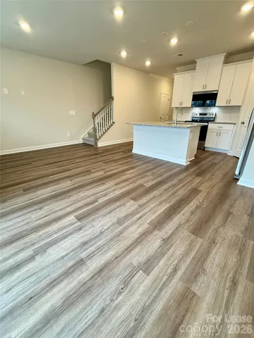 a view of kitchen with cabinets microwave and stove