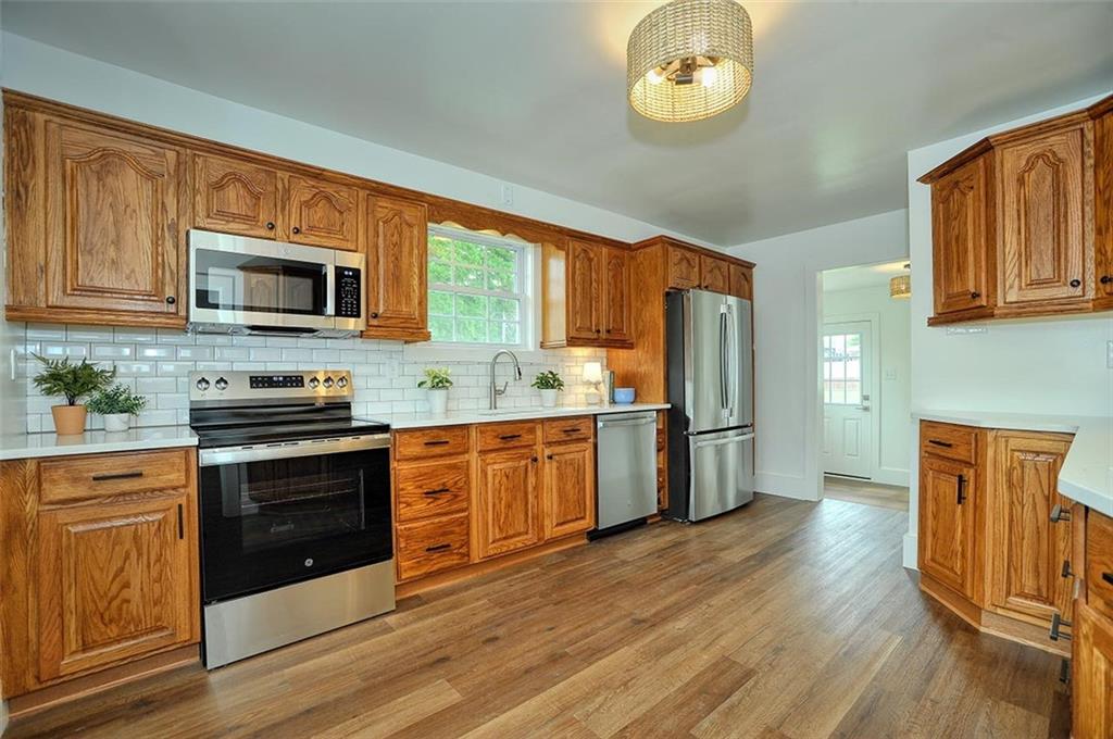 113 3rd Street Houston, PA 15342 - Photo 7 of 27 a kitchen with stainless steel appliances granite countertop a stove top oven a refrigerator a sink and dishwasher with wooden floor