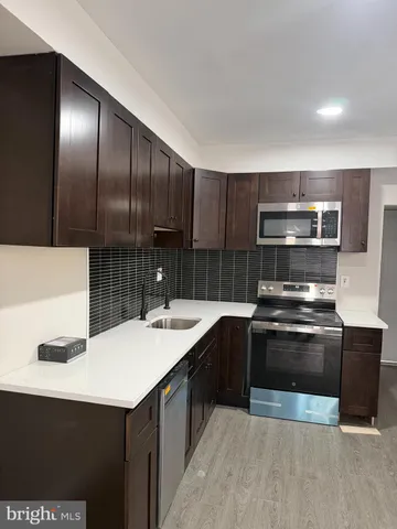 a kitchen with a sink cabinets and stainless steel appliances