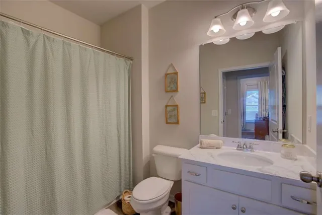 a bathroom with a double vanity sink toilet and a mirror