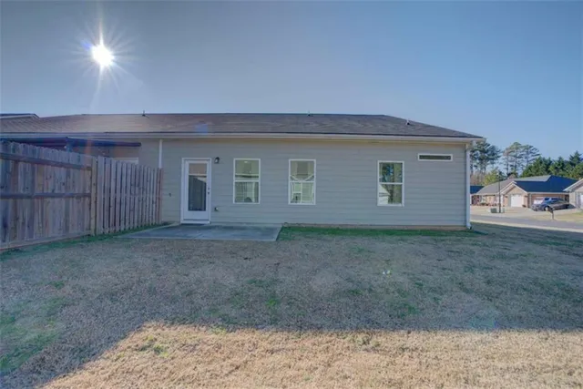 a view of an empty room with a yard and wooden fence