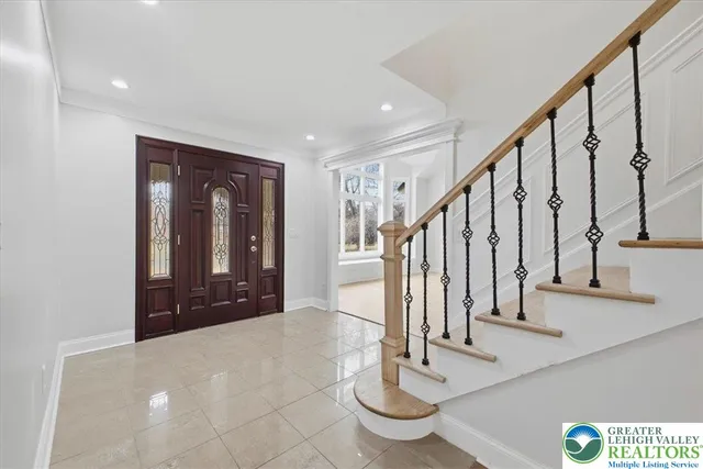 an empty room with wooden floor fireplace and windows