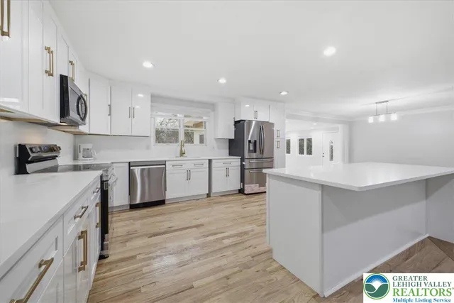 a kitchen with white cabinets and stainless steel appliances