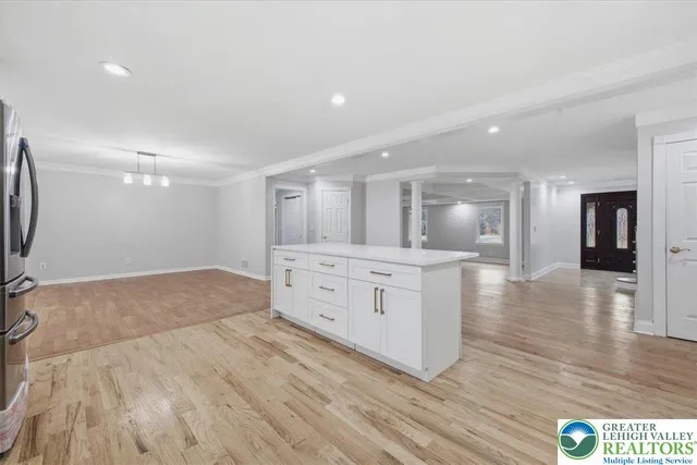 a view of an empty room with wooden floor fireplace and a window